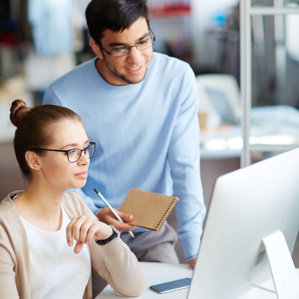 two employees at computer showing training